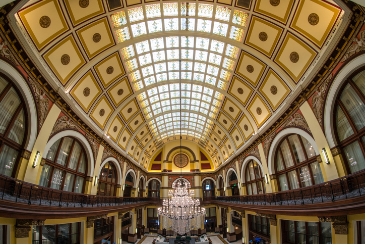 Elegant interior of a historic hotel featuring preserved architectural details, such as rounded mouldings ornate ceiling, numerous skylights